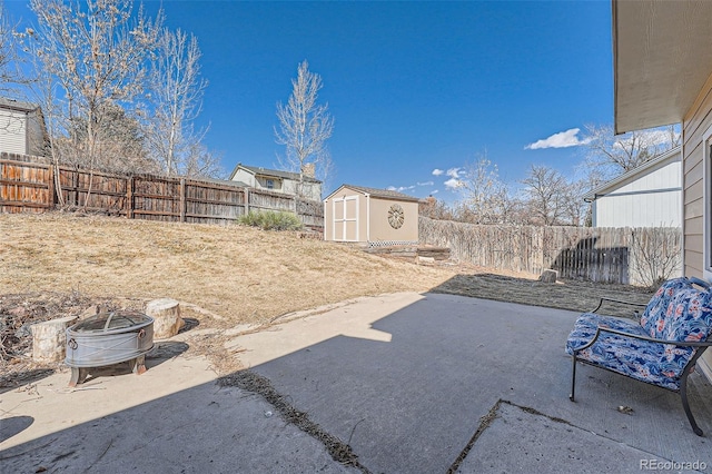 view of patio / terrace with an outbuilding, a fenced backyard, and a shed