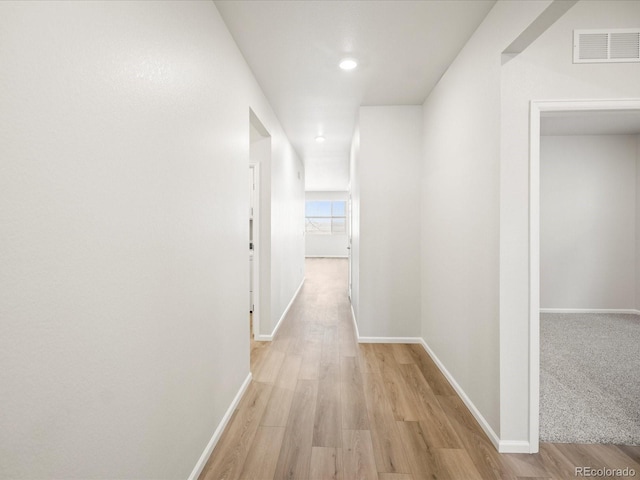 hallway featuring recessed lighting, visible vents, baseboards, and light wood-style flooring