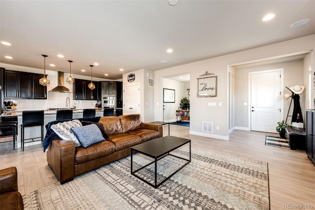 living room with sink and light hardwood / wood-style flooring