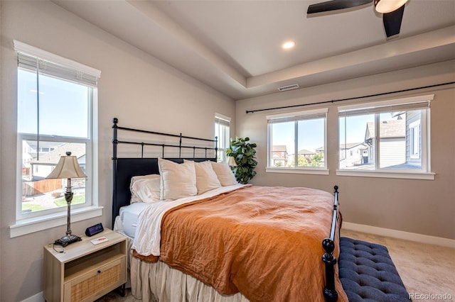 bedroom featuring light carpet, multiple windows, and ceiling fan