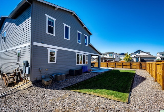 back of property featuring cooling unit, a yard, and a patio area