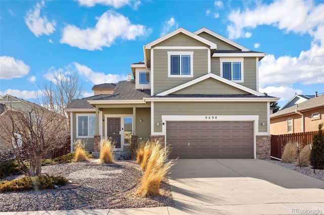 craftsman house featuring a garage, concrete driveway, stone siding, and fence