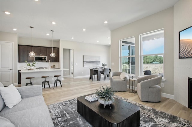 living room with sink and light hardwood / wood-style flooring