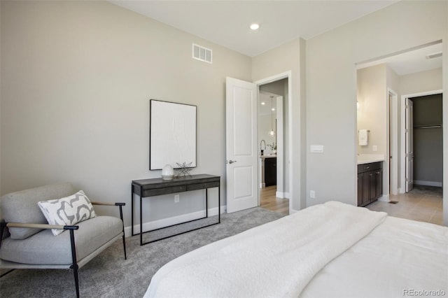 carpeted bedroom featuring ensuite bath