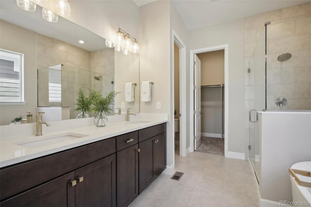 bathroom with vanity, a shower with shower door, tile patterned floors, and toilet