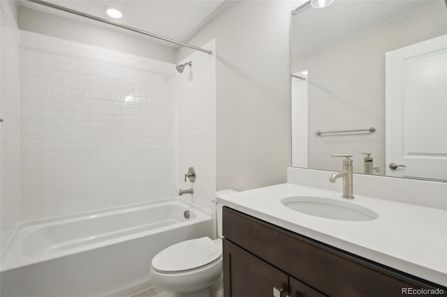 full bathroom featuring tiled shower / bath, vanity, and toilet