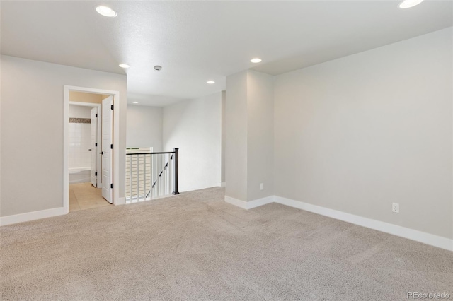 spare room featuring light carpet, baseboards, and recessed lighting