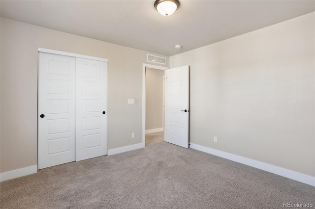 unfurnished bedroom featuring carpet, a closet, visible vents, and baseboards