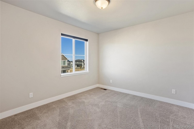 carpeted empty room featuring visible vents and baseboards