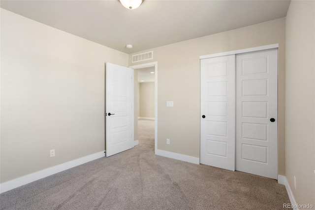 unfurnished bedroom with baseboards, a closet, visible vents, and light colored carpet