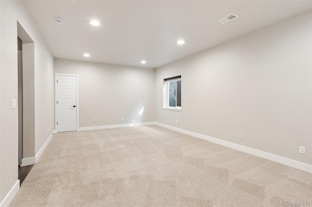 unfurnished room with recessed lighting, light colored carpet, visible vents, and baseboards