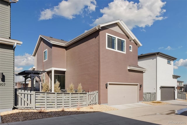 view of side of home with a garage, concrete driveway, and fence