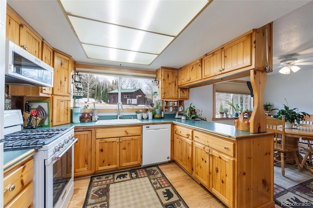 153 Gcr 135, Kremmling, CO 80459 - kitchen featuring a ceiling fan, white appliances, a sink, a peninsula, and light wood-style floors