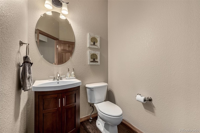 bathroom with vanity, toilet, and wood-type flooring