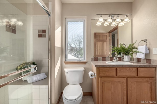 bathroom with tile patterned flooring, vanity, toilet, and walk in shower