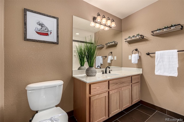 bathroom featuring toilet, vanity, and tile patterned floors