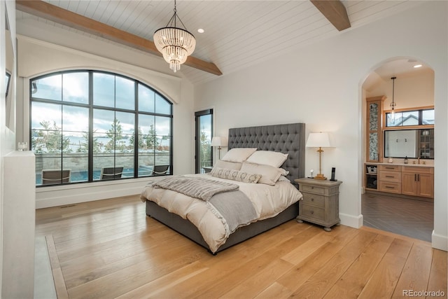 bedroom featuring light wood-type flooring, vaulted ceiling with beams, wooden ceiling, and an inviting chandelier