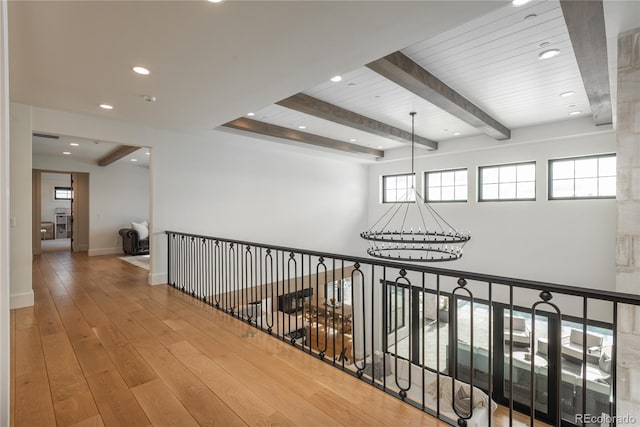 hallway with beamed ceiling, a chandelier, hardwood / wood-style flooring, and plenty of natural light