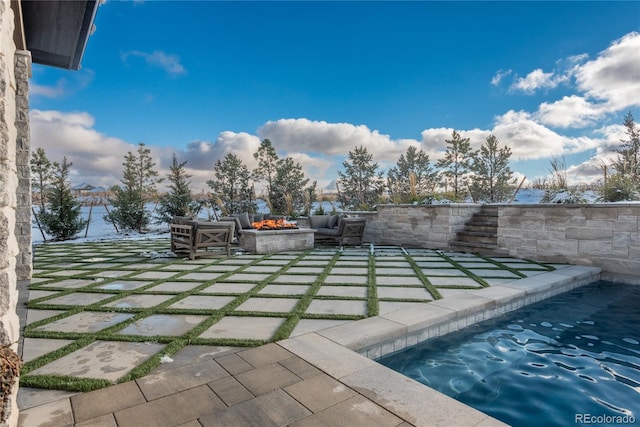 view of pool with a patio area and a fire pit