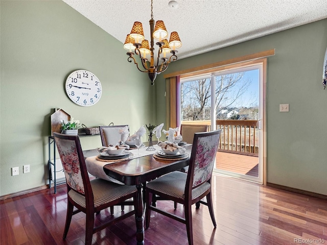 dining room with a textured ceiling, baseboards, hardwood / wood-style flooring, and a notable chandelier