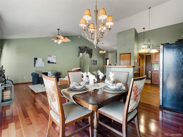 dining space featuring hardwood / wood-style floors, a textured ceiling, high vaulted ceiling, baseboards, and ceiling fan with notable chandelier