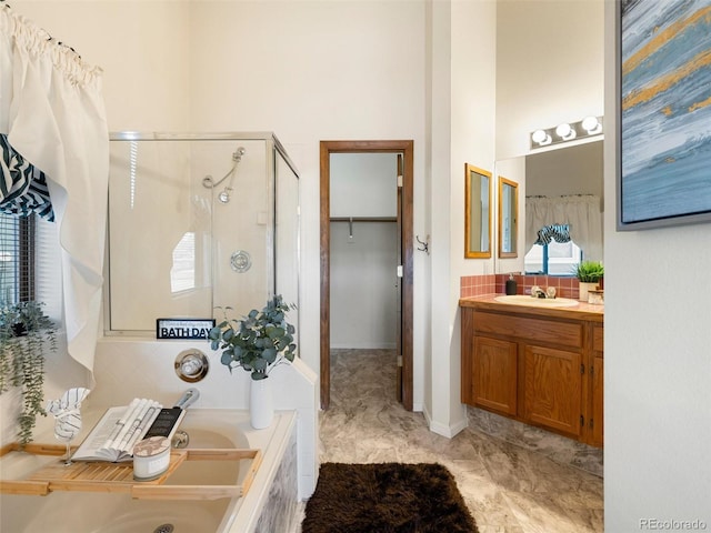 bathroom featuring a garden tub, a high ceiling, decorative backsplash, a shower stall, and vanity