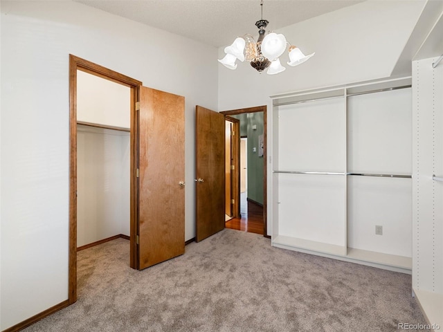 unfurnished bedroom with carpet floors, lofted ceiling, a closet, and a chandelier