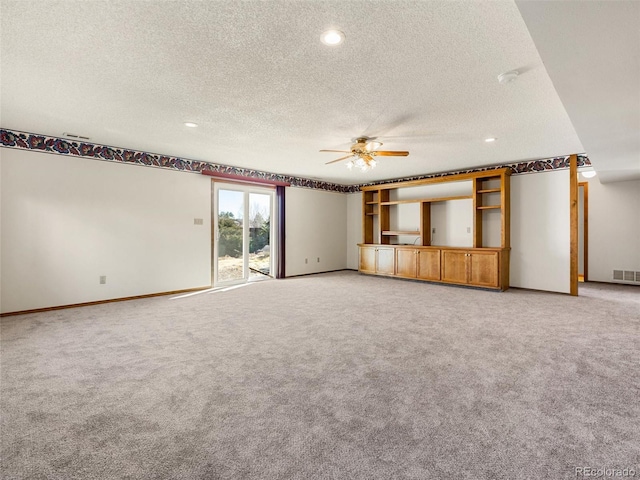 unfurnished living room featuring ceiling fan, a textured ceiling, light carpet, visible vents, and baseboards