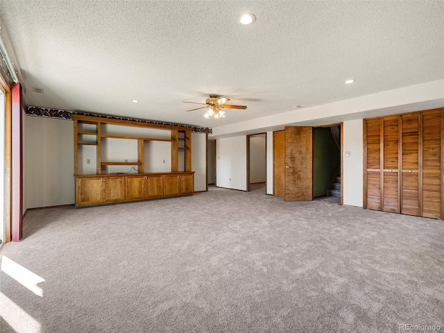 interior space with recessed lighting, light colored carpet, stairway, a ceiling fan, and a textured ceiling