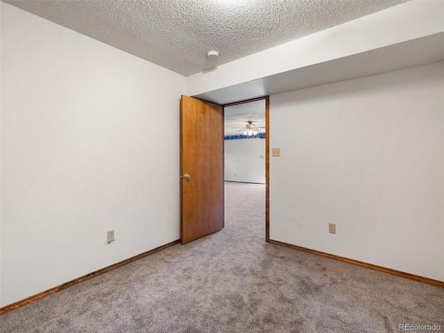 spare room featuring carpet floors, baseboards, and a textured ceiling