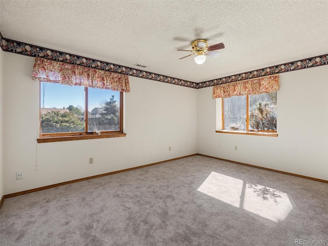 unfurnished room with carpet, visible vents, and a textured ceiling