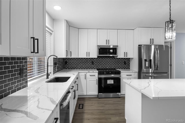 kitchen with appliances with stainless steel finishes, a sink, and white cabinetry