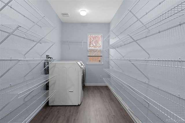 laundry area featuring laundry area, washer / dryer, baseboards, visible vents, and wood finished floors