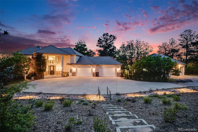 10914 Remmick Ridge Rd, Parker, CO 80134 - view of front facade with stucco siding, stone siding, an attached garage, driveway, and a tiled roof