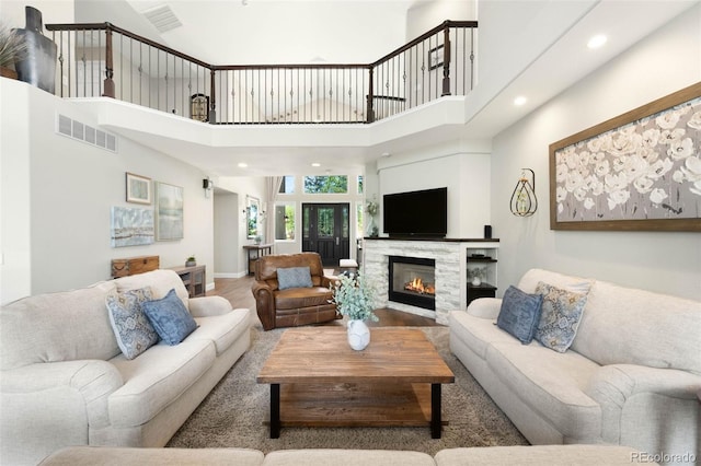 10914 Remmick Ridge Rd, Parker, CO 80134 - living area with a towering ceiling, a glass covered fireplace, recessed lighting, and baseboards