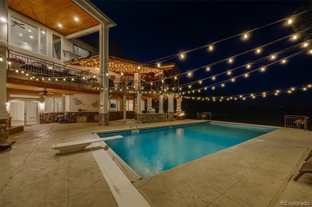 10914 Remmick Ridge Rd, Parker, CO 80134 - pool at twilight featuring a patio area, a diving board, an outdoor pool, and ceiling fan