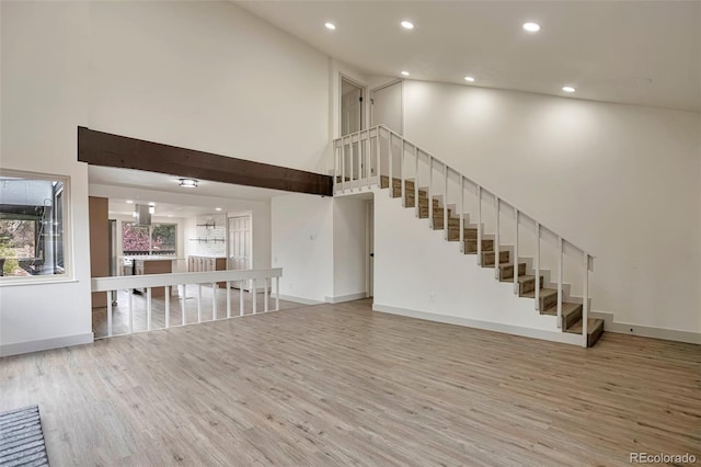 12164 E Amherst Cir, Aurora, CO 80014 - unfurnished living room featuring recessed lighting, wood finished floors, a high ceiling, and stairs