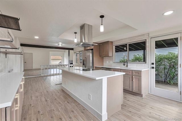 12164 E Amherst Cir, Aurora, CO 80014 - kitchen with a tray ceiling, light wood finished floors, island exhaust hood, and stainless steel fridge with ice dispenser