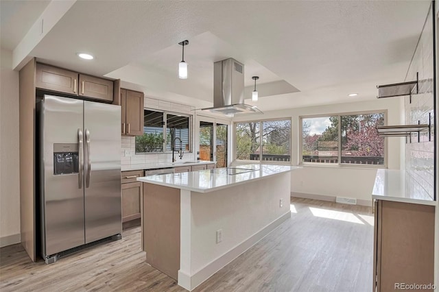 12164 E Amherst Cir, Aurora, CO 80014 - kitchen featuring light wood-style flooring, a tray ceiling, island range hood, baseboards, and appliances with stainless steel finishes