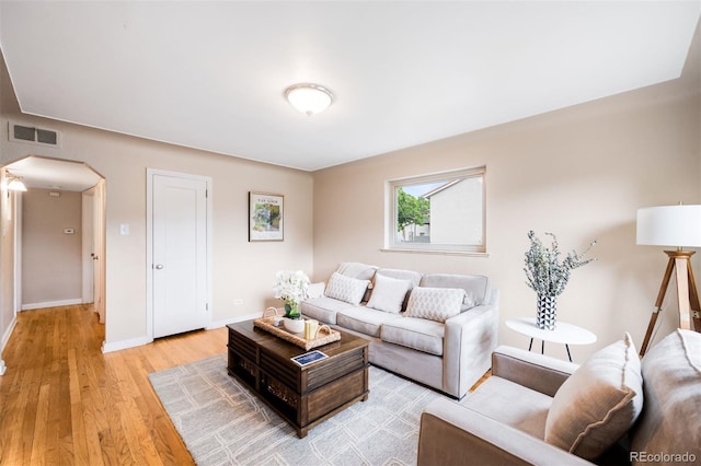 2255 Perry St, Denver, CO 80212 - living area featuring arched walkways, light wood-type flooring, and baseboards