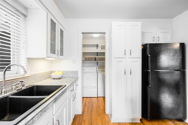 2255 Perry St, Denver, CO 80212 - kitchen with freestanding refrigerator, a sink, independent washer and dryer, and white cabinets