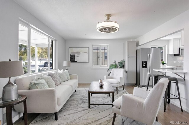 living room featuring light wood-type flooring and baseboards