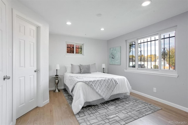 bedroom with baseboards, light wood-type flooring, and recessed lighting