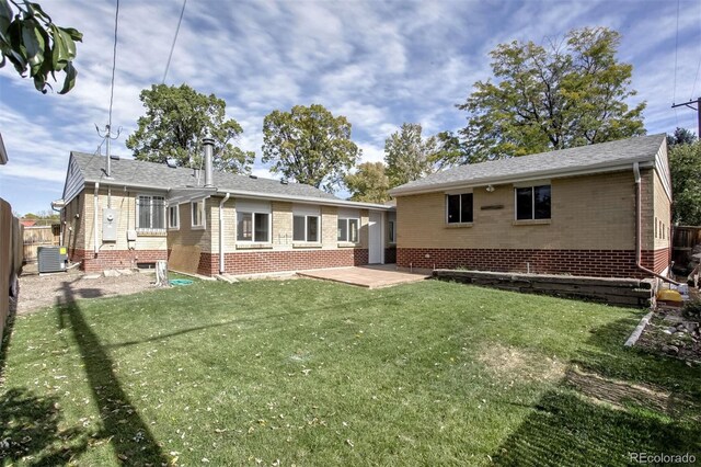 back of house with brick siding, fence, a patio, and a yard