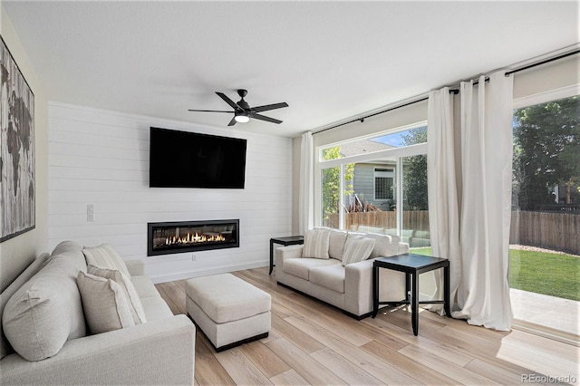 17174 E Rosebay Cir, Parker, CO 80134 - living area featuring a large fireplace, light wood finished floors, ceiling fan, and wooden walls