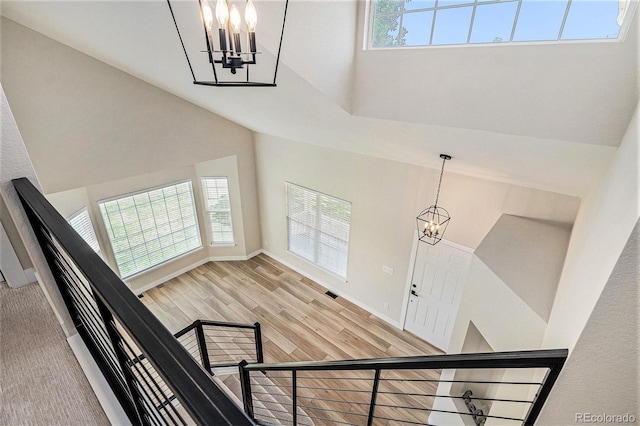 17174 E Rosebay Cir, Parker, CO 80134 - stairs featuring a chandelier, a towering ceiling, plenty of natural light, and wood finished floors
