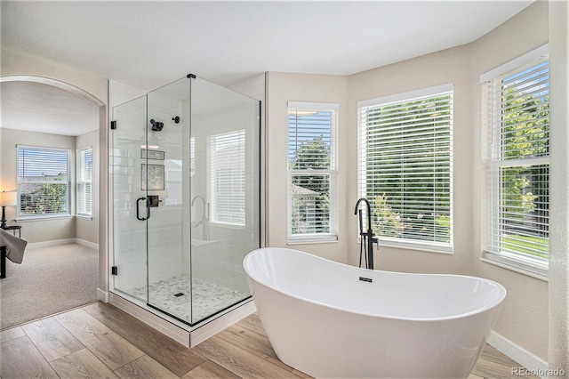 17174 E Rosebay Cir, Parker, CO 80134 - full bathroom featuring a soaking tub, wood finished floors, and a shower stall