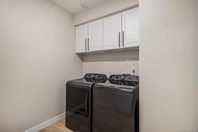 17174 E Rosebay Cir, Parker, CO 80134 - laundry area featuring washing machine and dryer, cabinet space, and light wood-type flooring
