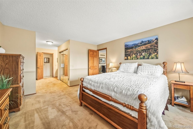 bedroom featuring a textured ceiling and light colored carpet