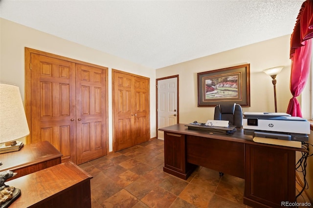 office space with a textured ceiling and stone finish flooring